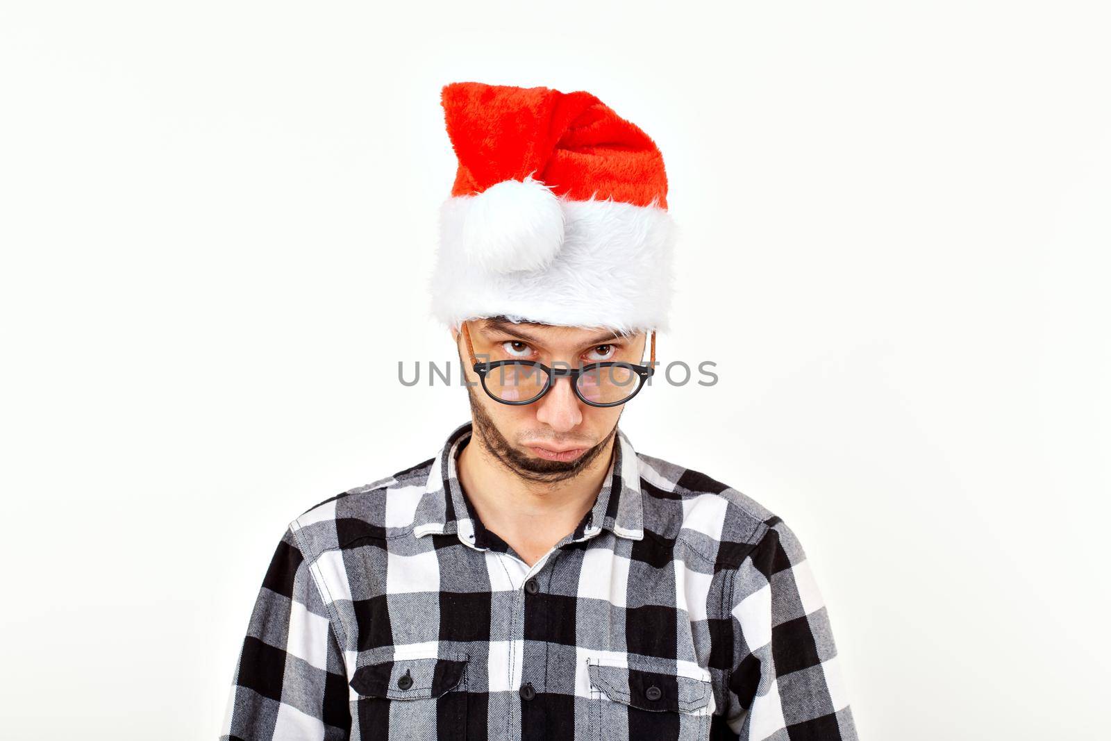 Portrait of a funny young man in Santa Claus hat and beard. Christmas