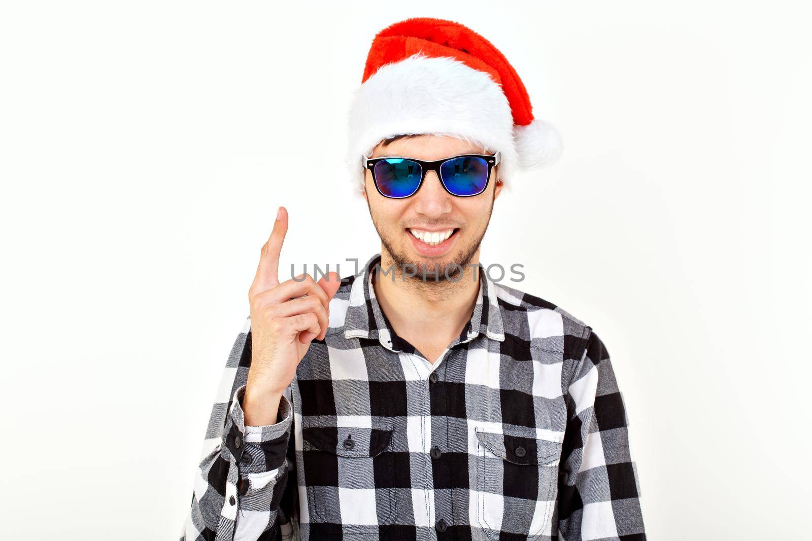 Portrait of a funny young man in Santa Claus hat and beard. Christmas