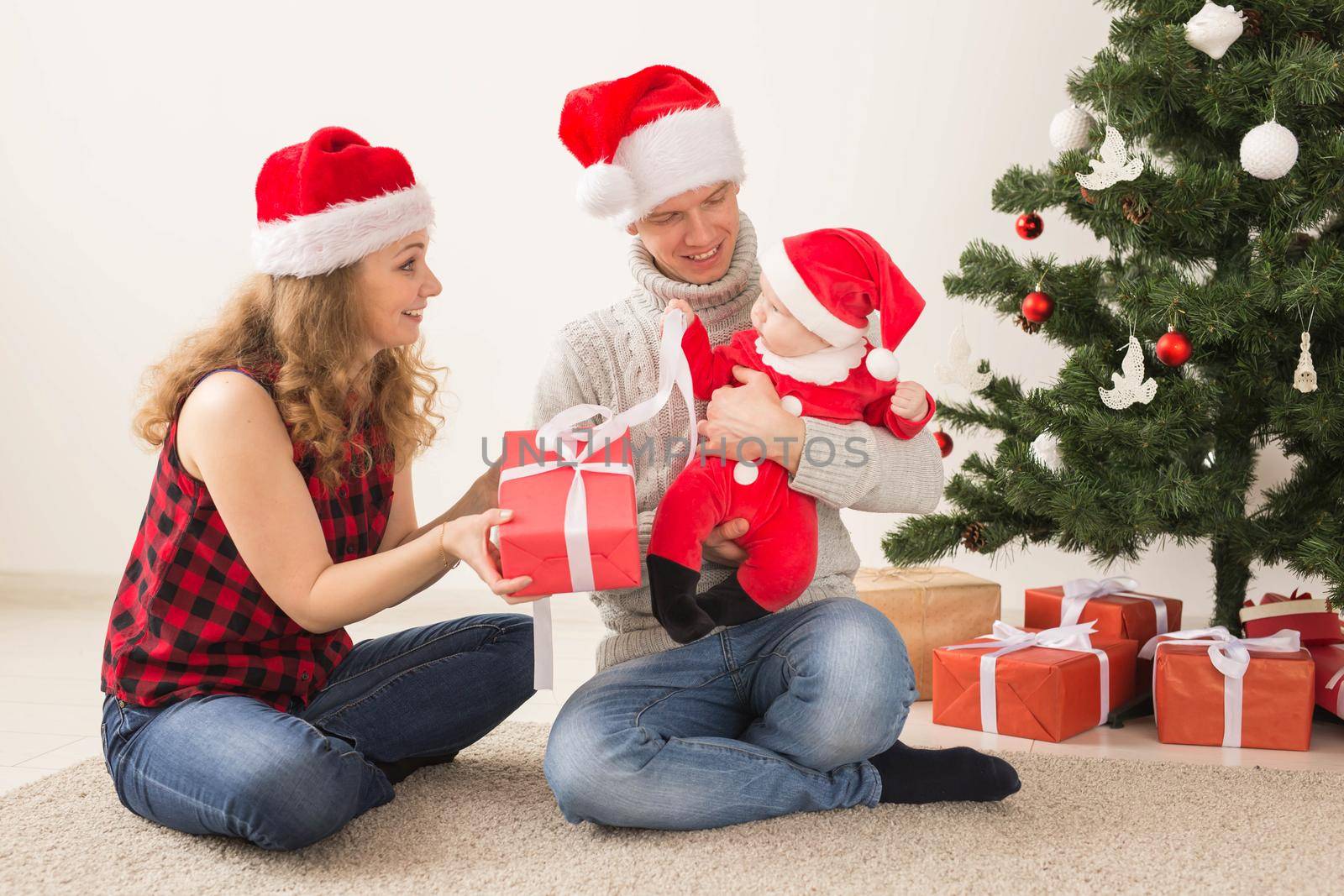 Happy couple with baby celebrating Christmas together at home. by Satura86