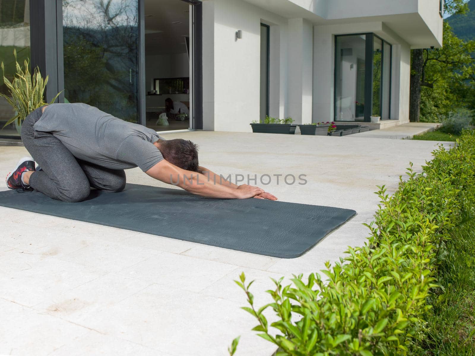 man doing morning yoga exercises by dotshock