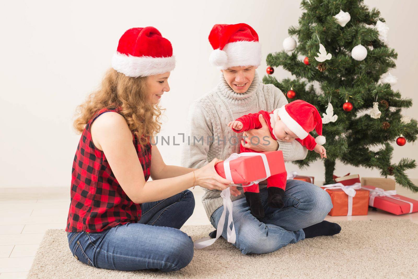 Happy couple with baby celebrating Christmas together at home