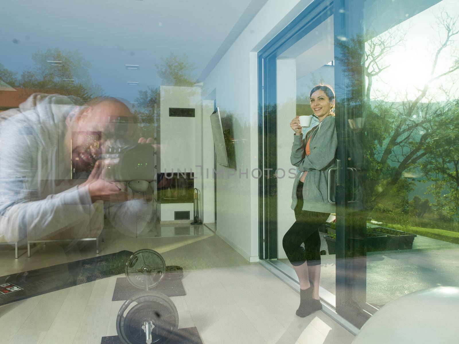 portrait of a young beautiful successful woman drinking coffee in the doorway of her luxury home villa