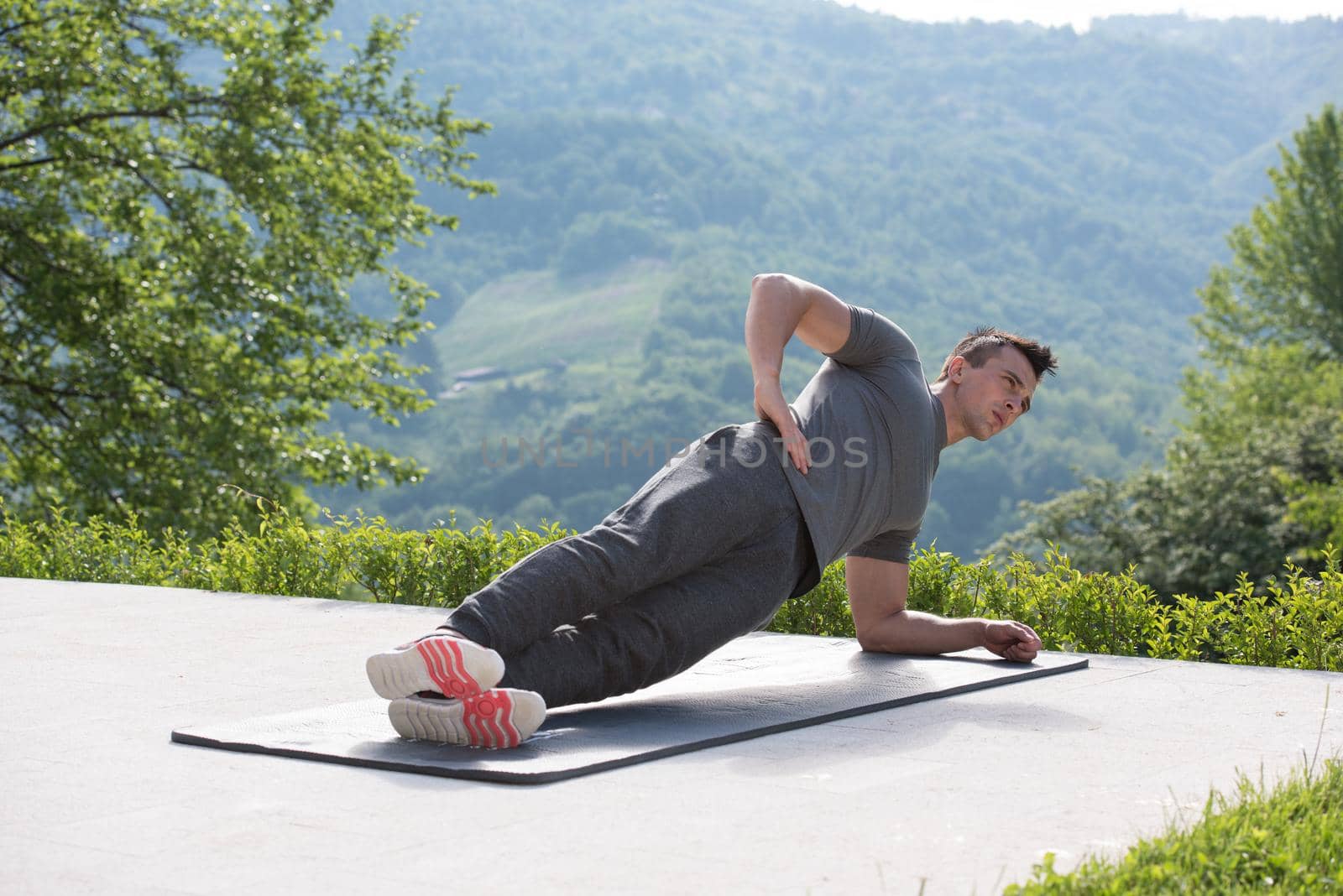 young handsome man doing morning yoga exercises in front of his luxury home villa