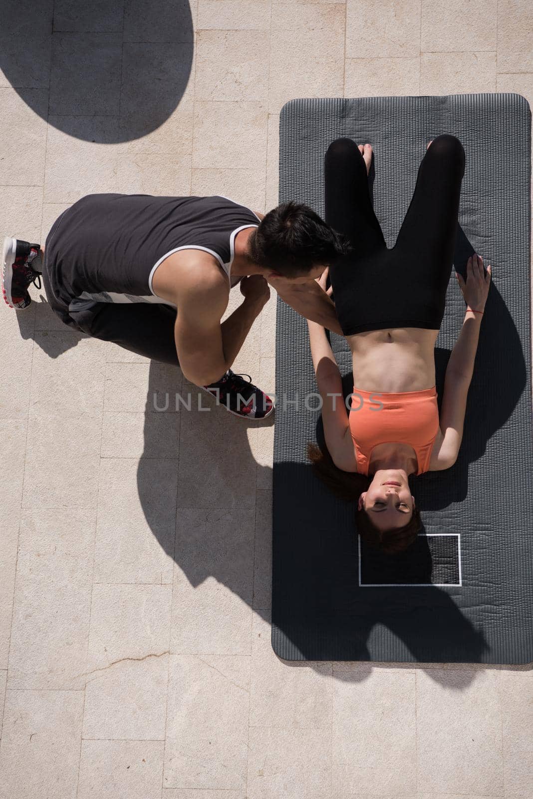 woman with personal trainer doing morning yoga exercises top view by dotshock