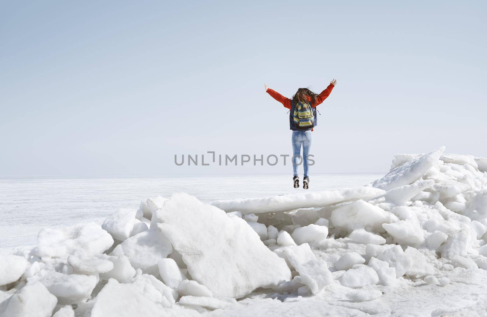 Young adult woman outdoors travelling with backpack in icy landscape by Novic