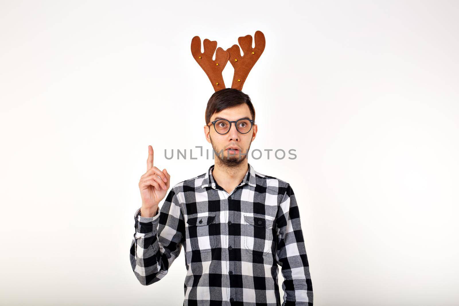 Christmas, holidays and funny concept - man with deer horns and rudolf nous on white background by Satura86