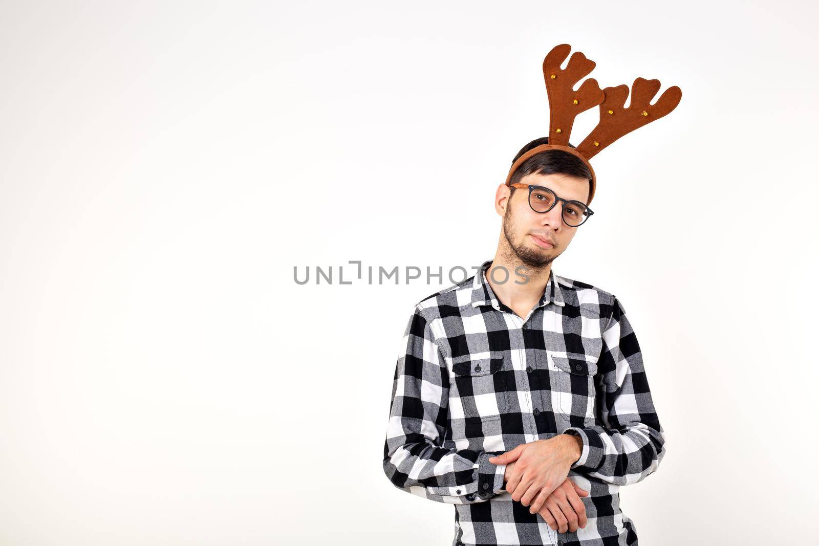 Christmas, holidays and funny concept - man with deer horns and rudolf nous.