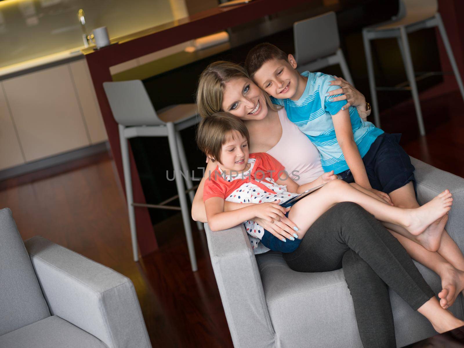 Happy Family Lying Down On The Sofa And Using Tablet