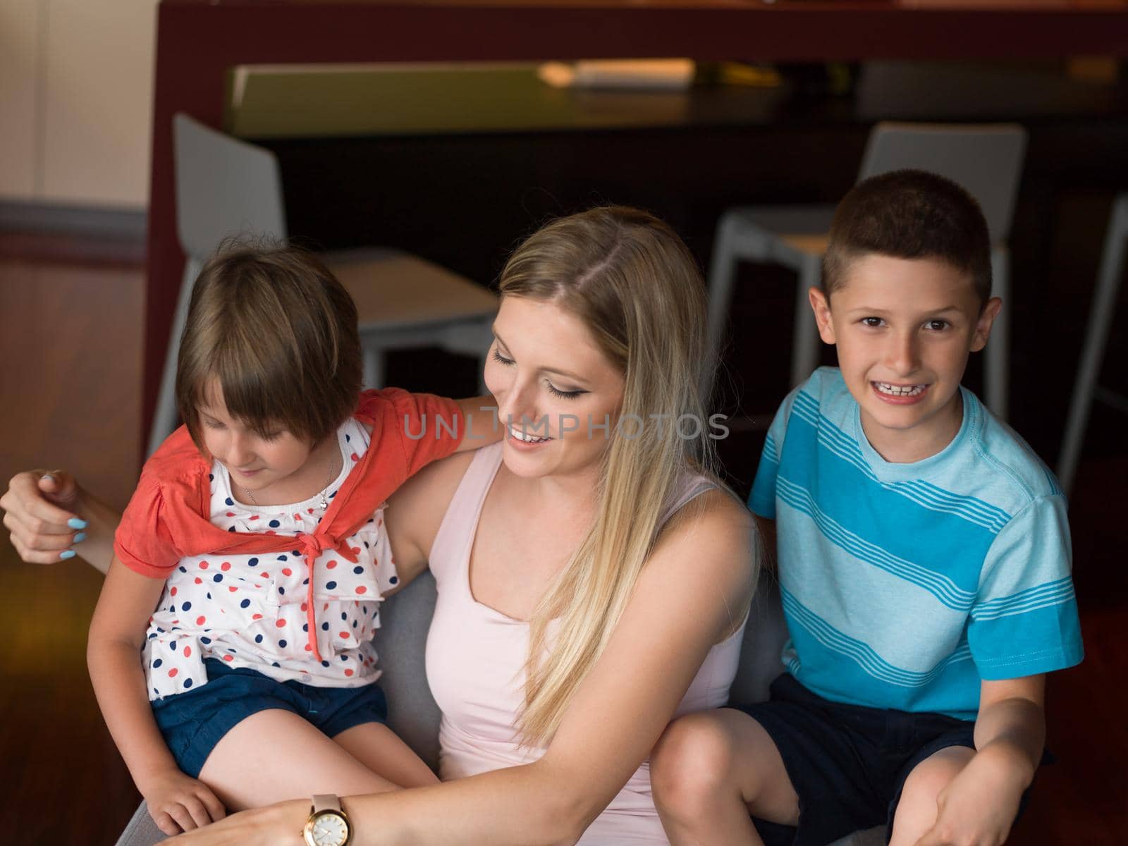 Happy family siting on sofa and using cell phone for video call  at home