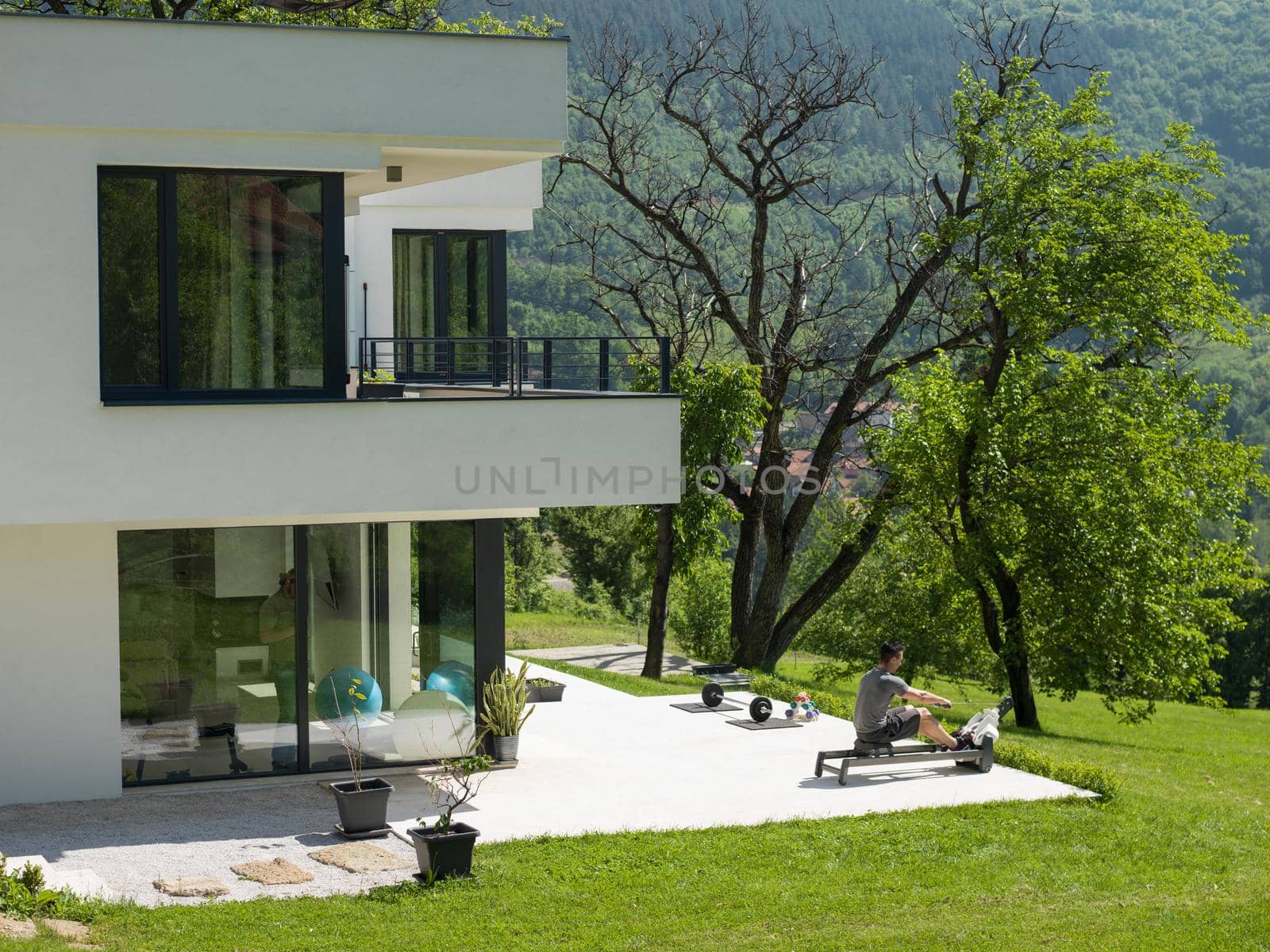 young handsome man doing morning exercises in front of his luxury home villa