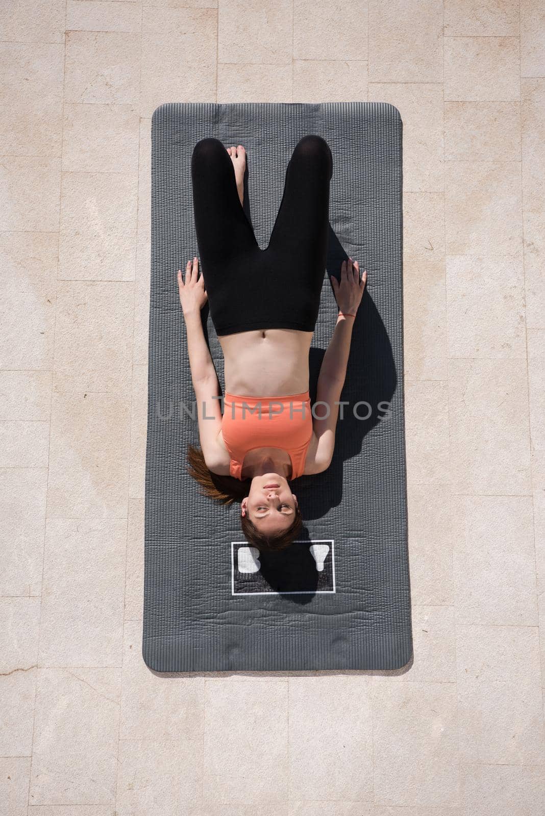 young handsome woman doing morning yoga exercises in front of her luxury home villa top view