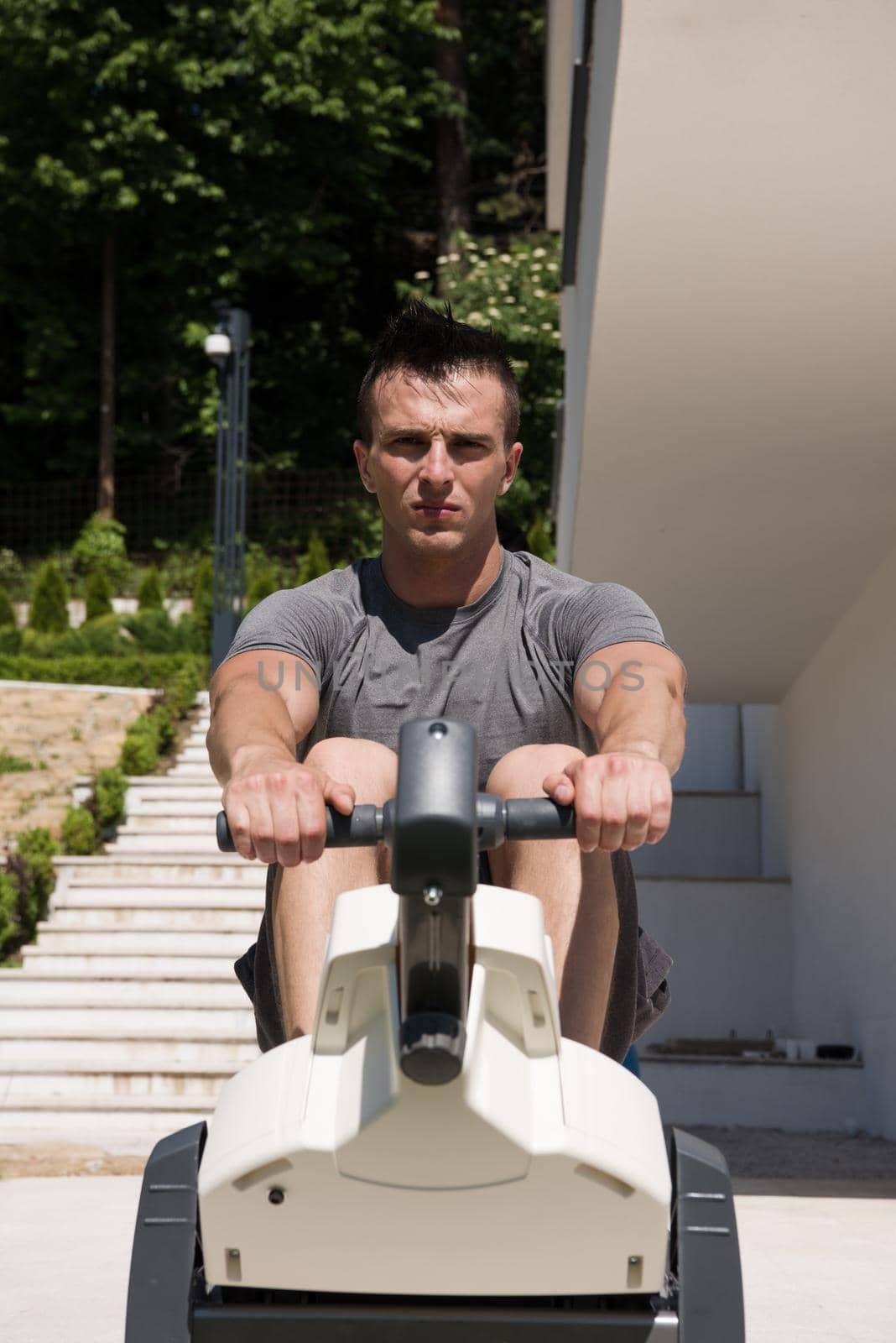 young handsome man doing morning exercises in front of his luxury home villa