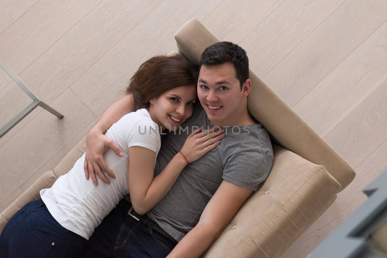 young handsome couple enjoys hugging on the sofa in their luxury home villa