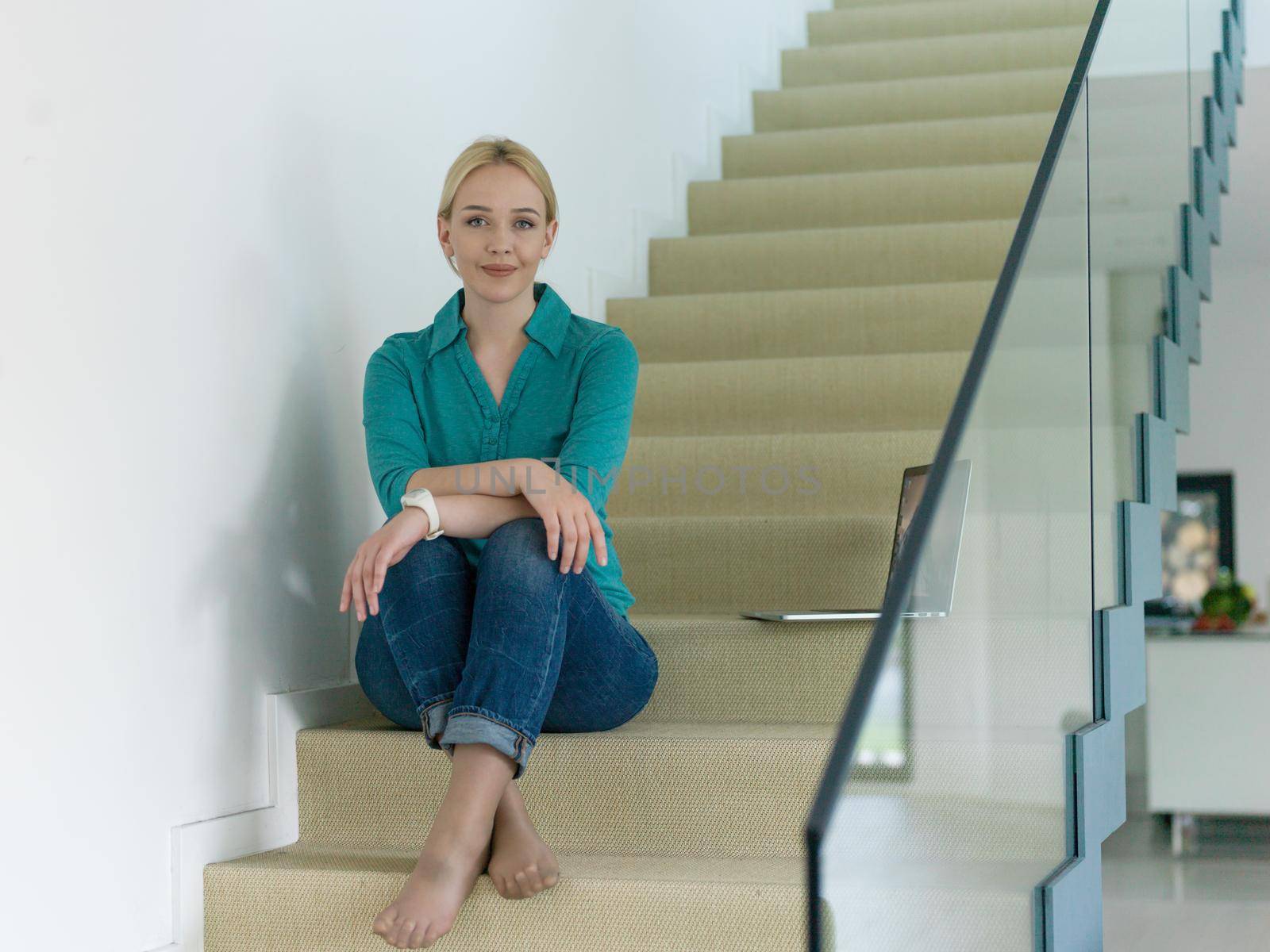 portrait of a young beautiful woman on the stairs in her luxurious home