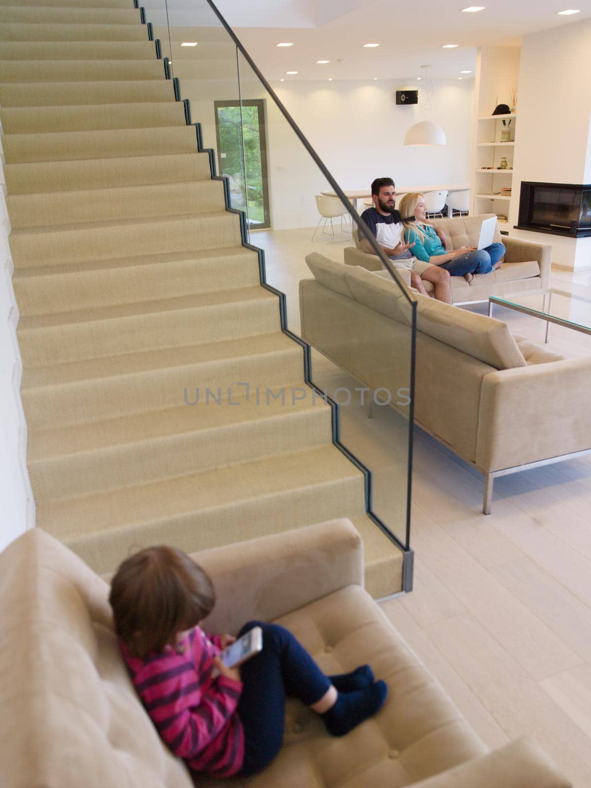 happy young family with little girl enjoys in the modern living room of their luxury home villa