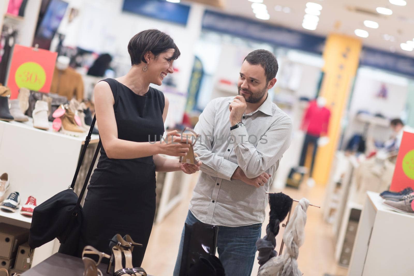 A young attractive couple changes the look with new shoes  At Shoe Store