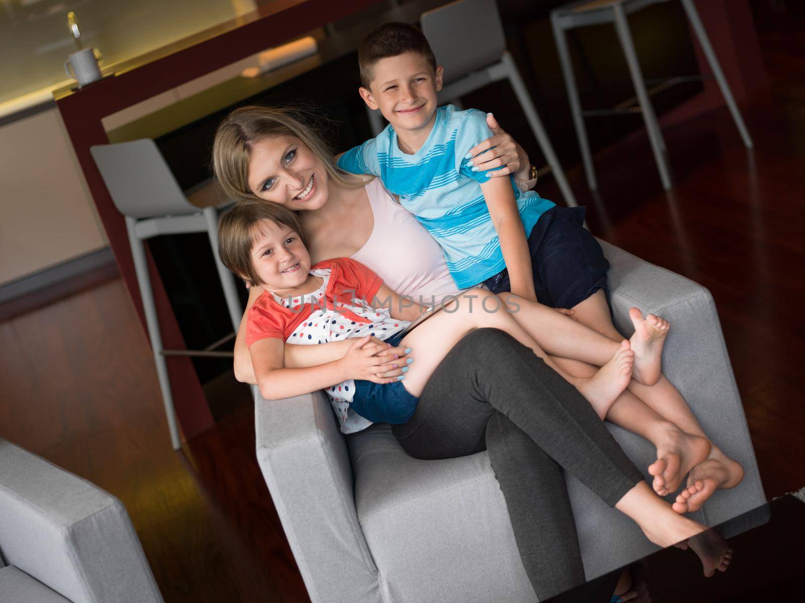 Happy Family Lying Down On The Sofa And Using Tablet