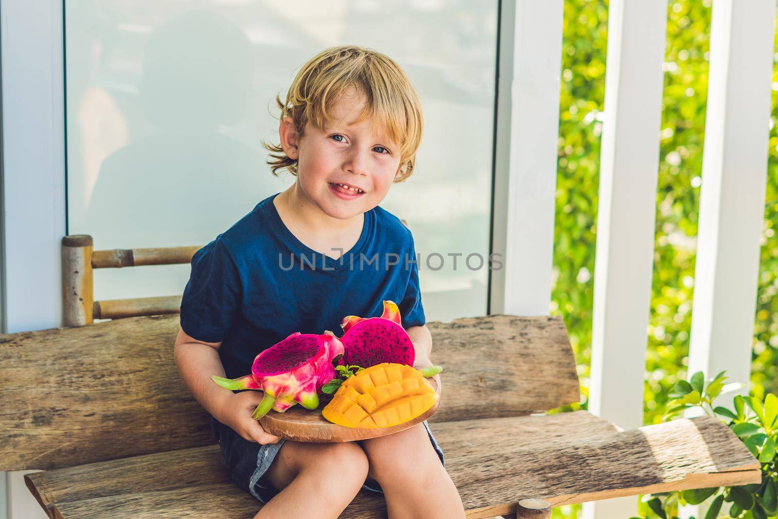 Diced dragon fruit and mango in the hands of the boy by galitskaya