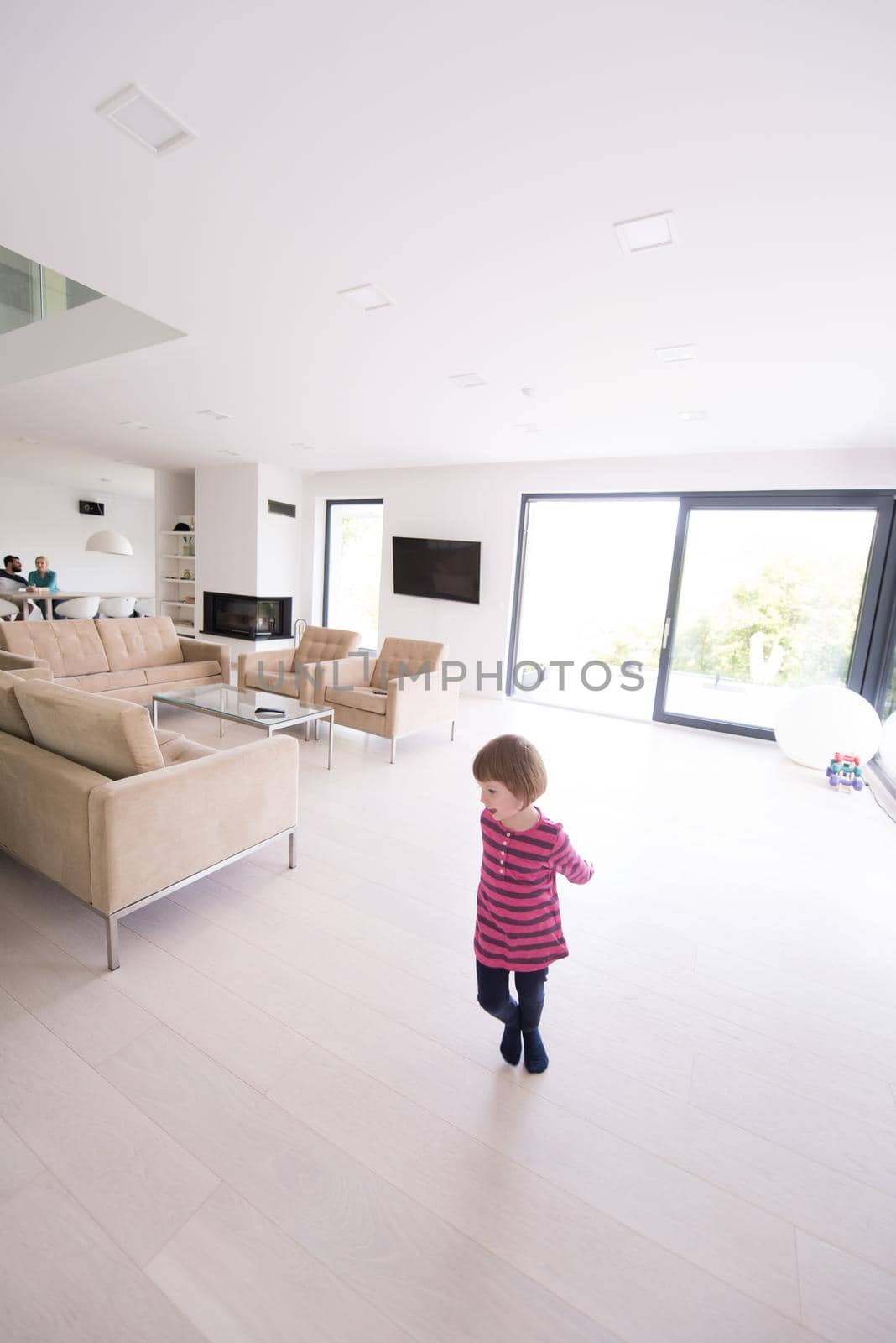 happy young family with little girl enjoys in the modern living room of their luxury home villa