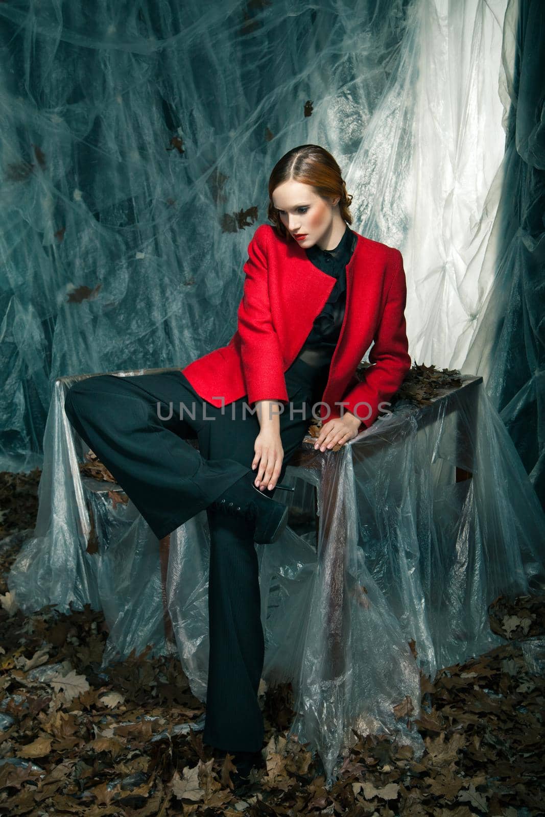 portrait of beautiful woman wearing red jacket and pants against autumn decoration
