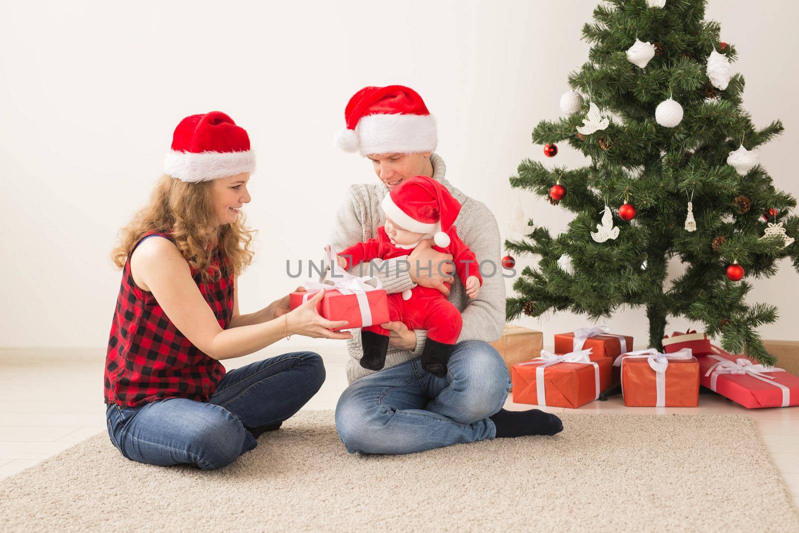 Happy couple with baby celebrating Christmas together at home