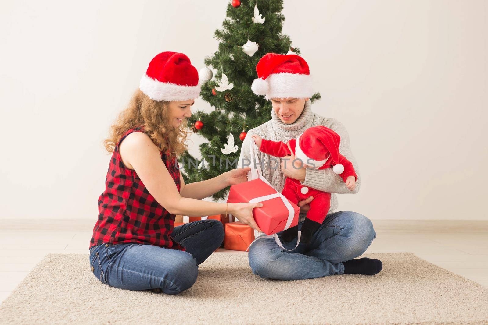 Happy couple with baby celebrating Christmas together at home