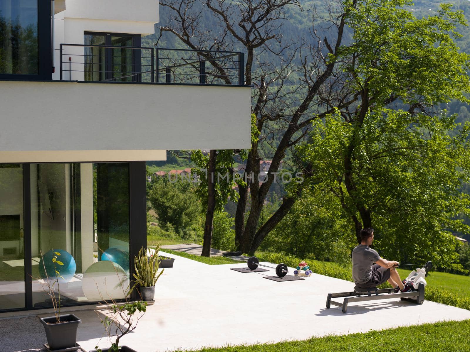 young handsome man doing morning exercises in front of his luxury home villa