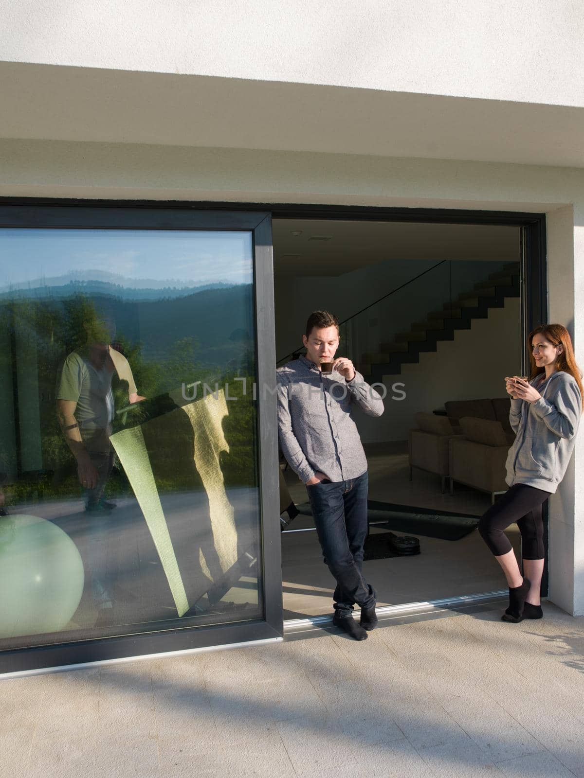 couple enjoying on the door of their luxury home villa by dotshock