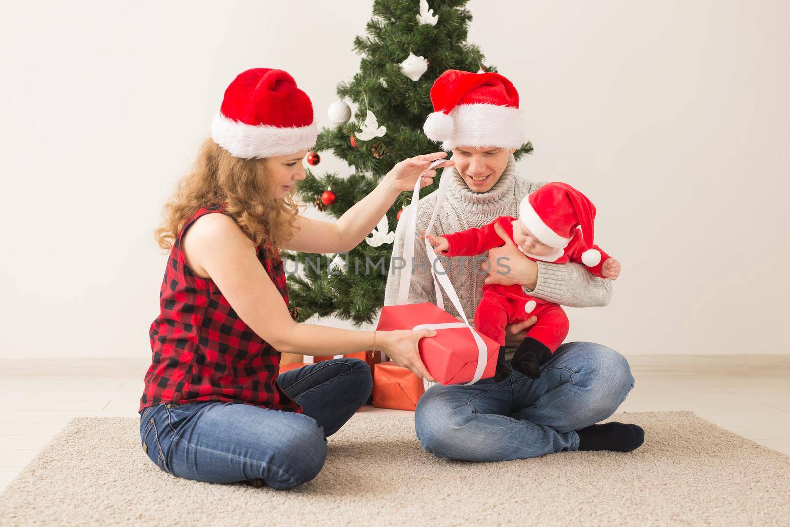 Happy couple with baby celebrating Christmas together at home