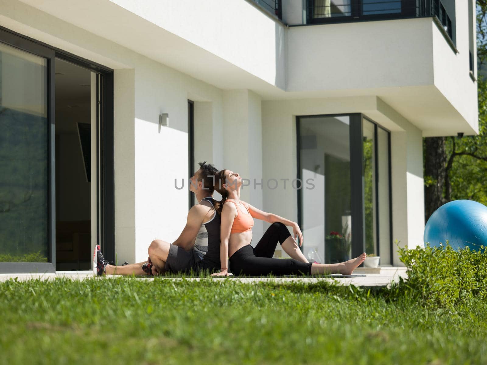 woman with personal trainer doing morning yoga exercises by dotshock
