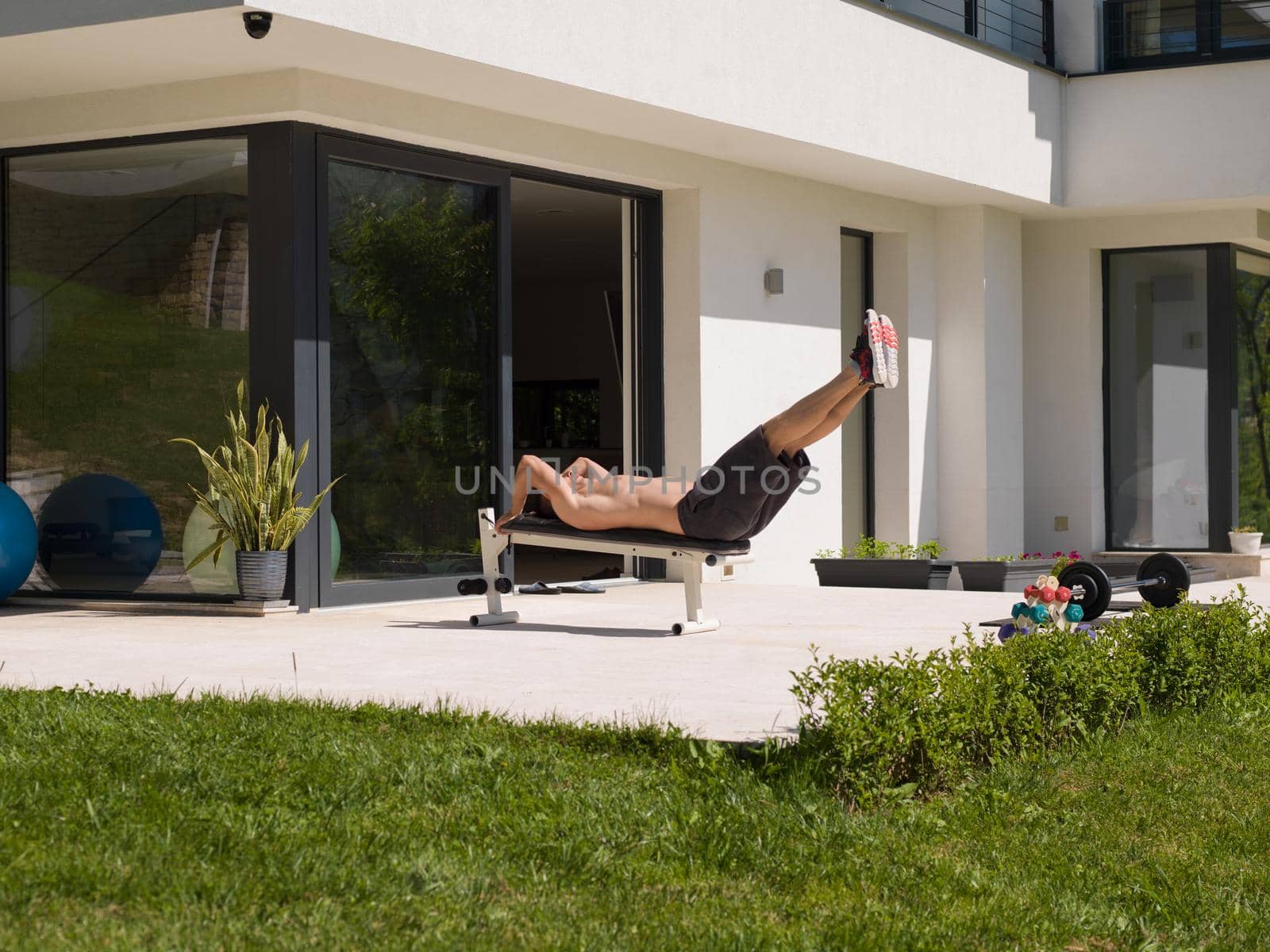 young handsome man doing morning exercises in front of his luxury home villa