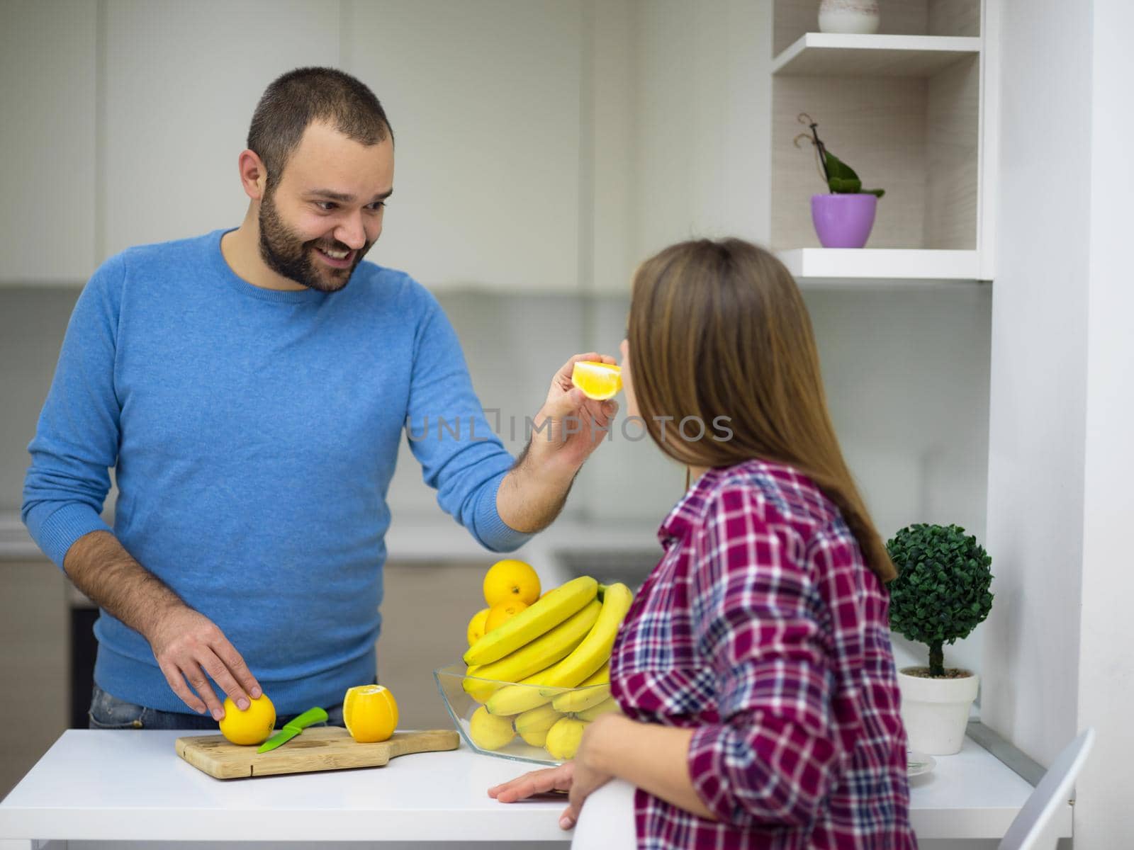 young pregnant couple cooking food fruit lemon juice at kitchen, lifestyle healthy pregnancy happy life concept