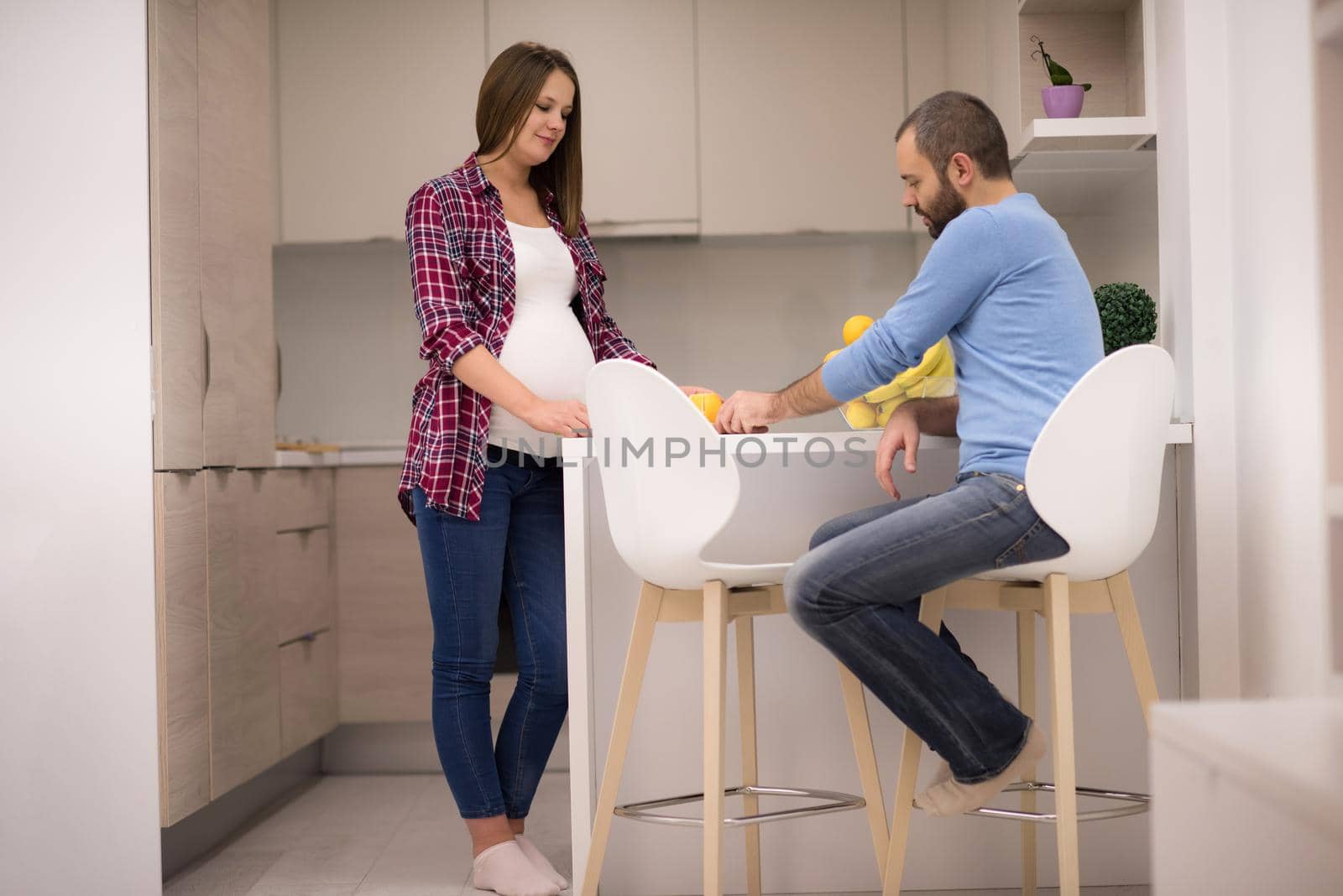 young pregnant couple cooking food fruit lemon juice at kitchen, lifestyle healthy pregnancy happy life concept