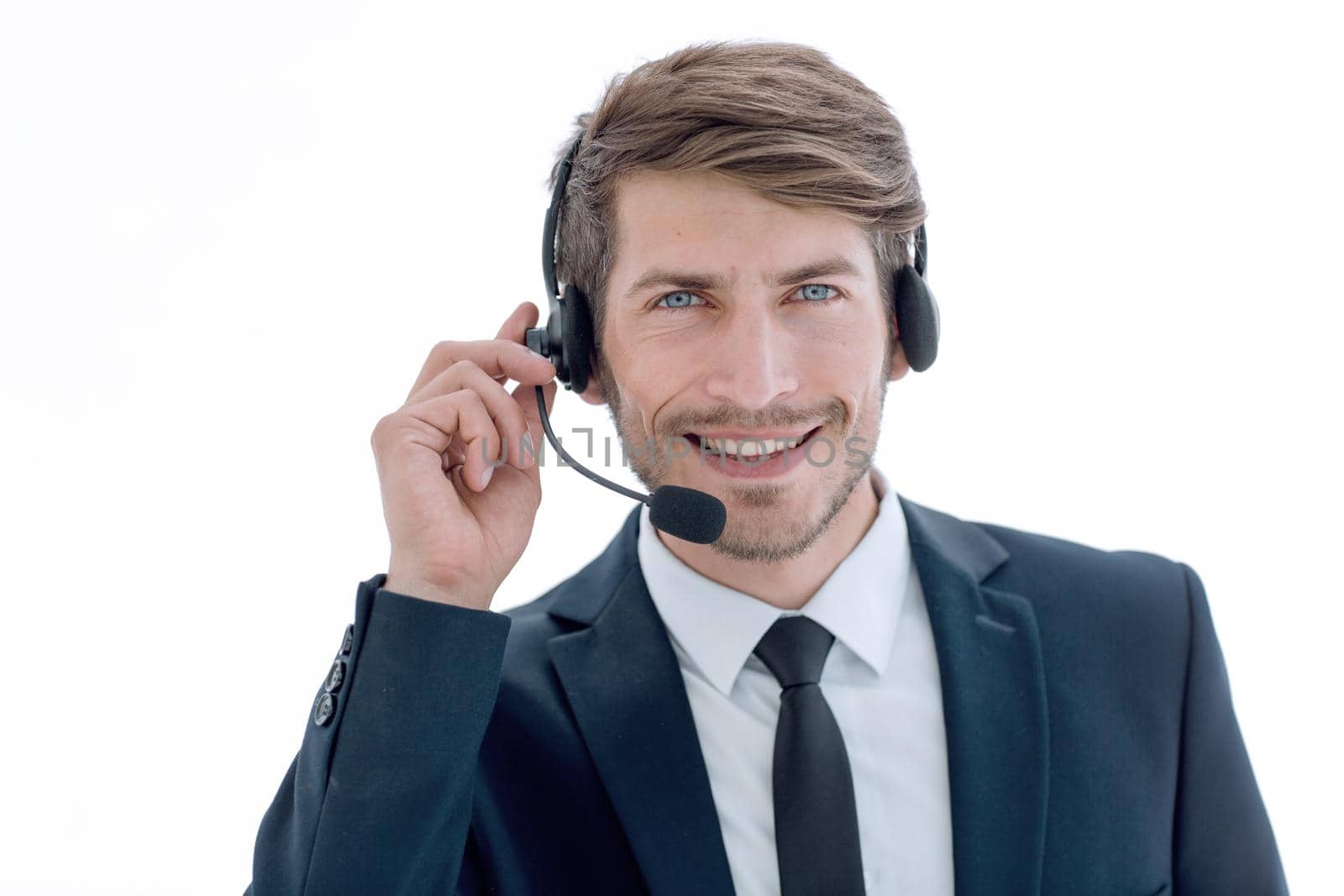 A young handsome businessman talking to the headphones and smile