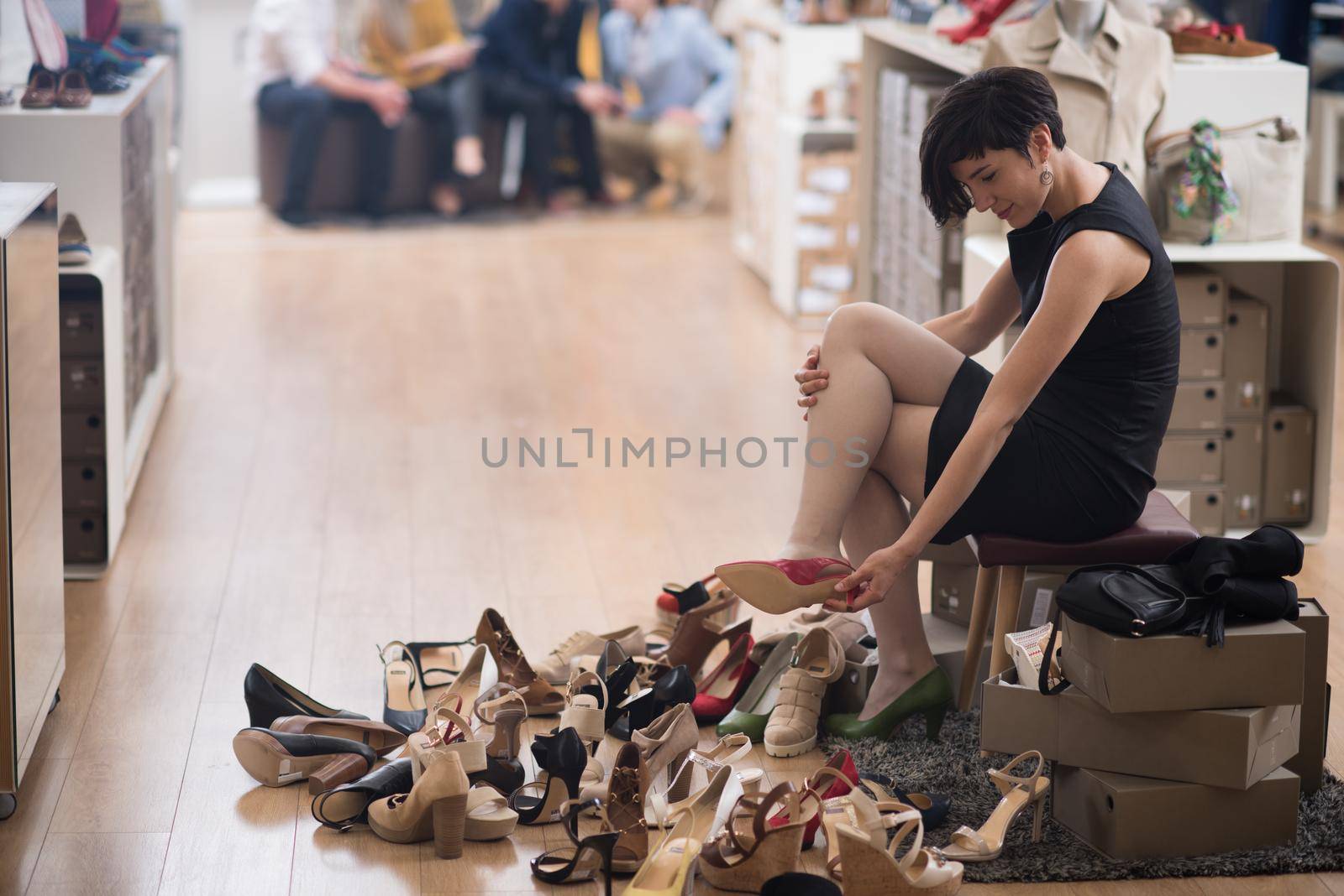 Woman Chooses  Shoes At Fashionable Shop