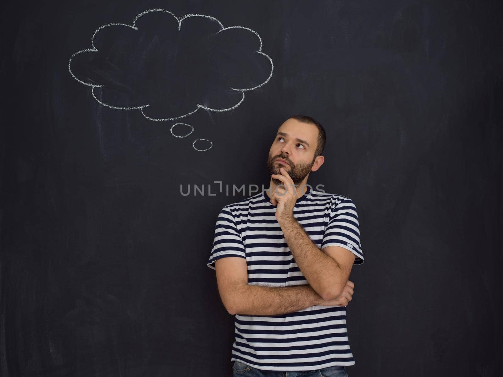 young future father thinking about names for his unborn baby to writing them on a black chalkboard