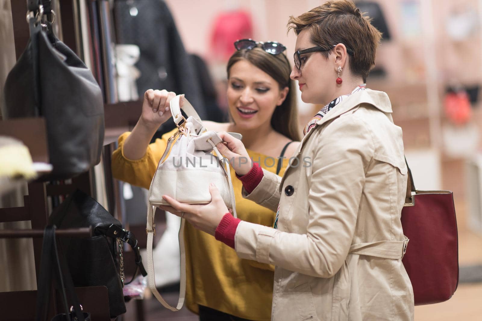 Two Girl-Friends On Shopping Walk On Shopping Centre With Bags And Choosing