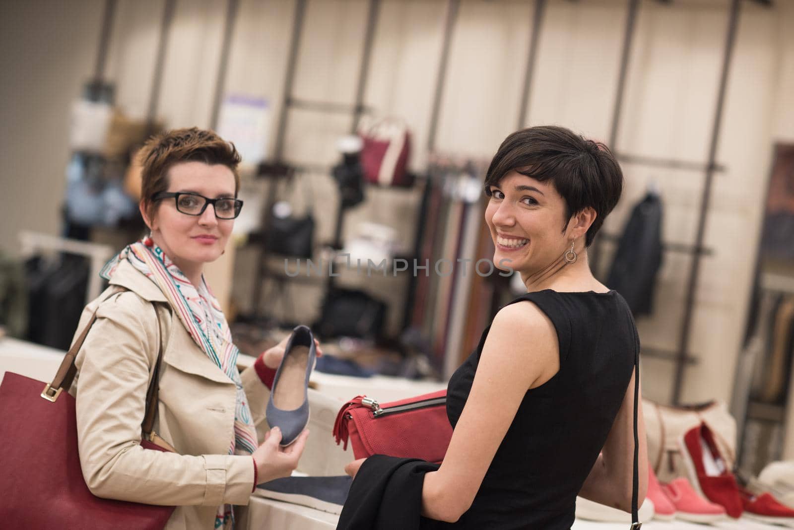 Two Girl-Friends On Shopping Walk On Shopping Centre With Bags And Choosing