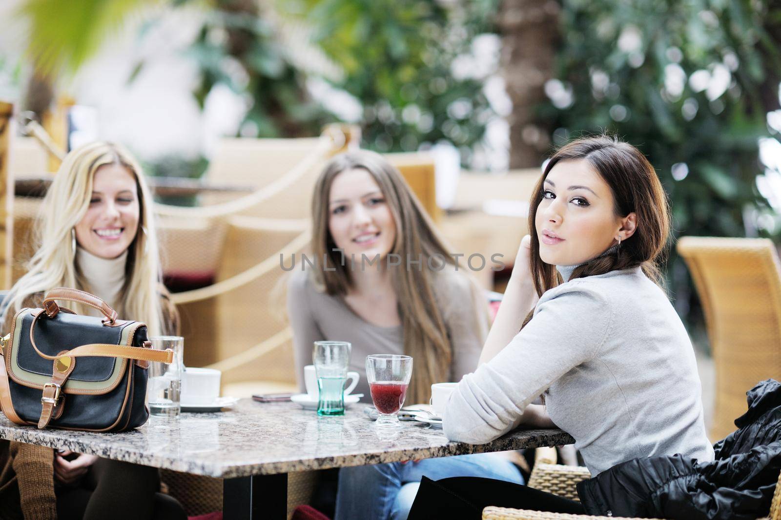 very cute smiling women drinking a coffee sitting inside in cafe restaurant