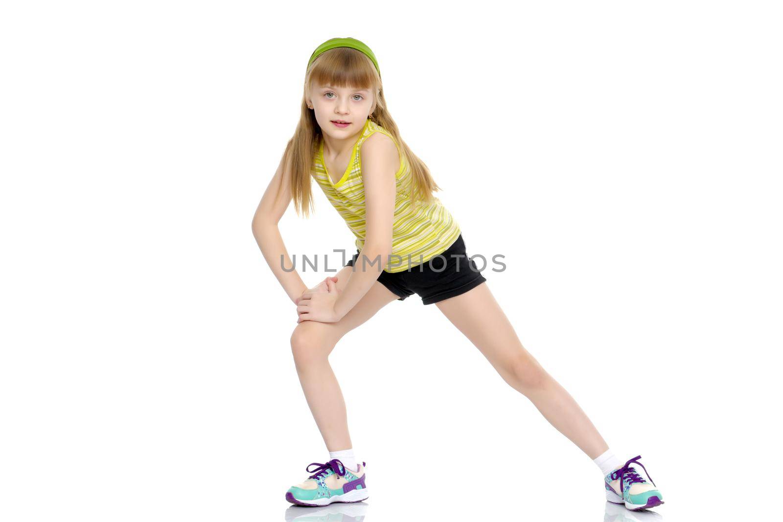 A gymnast girl prepares for the exercise. The concept of childhood and sport, a healthy lifestyle. Isolated on white background.