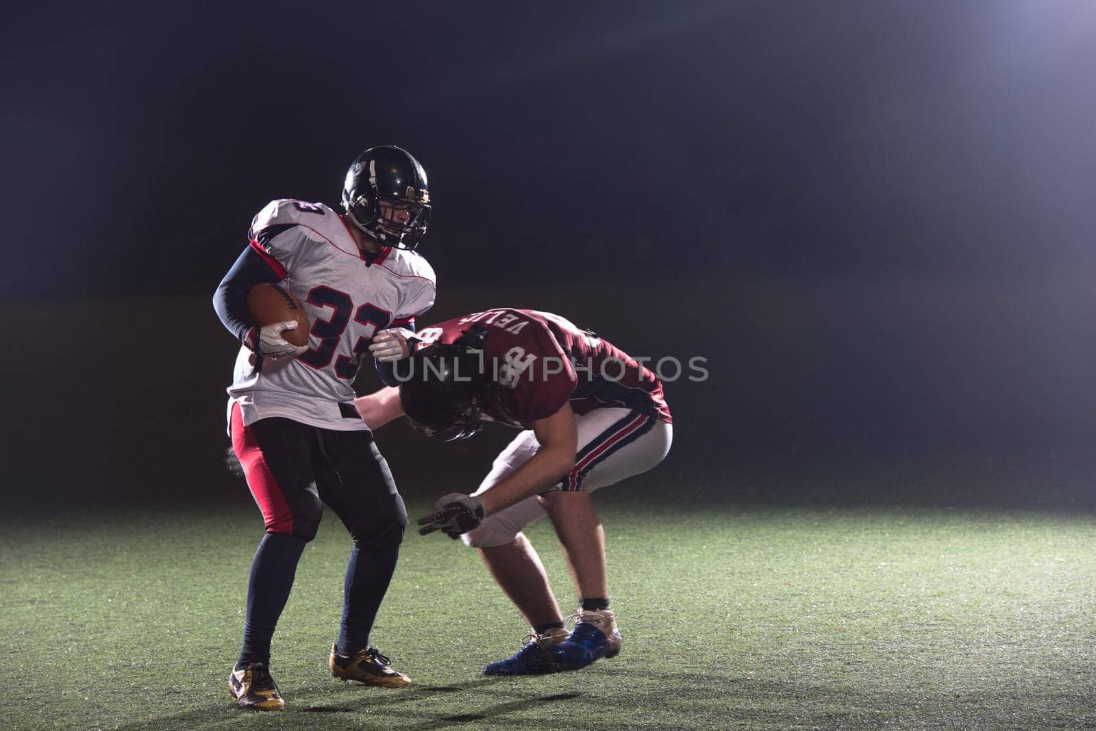 American football players in action at night game time on the field