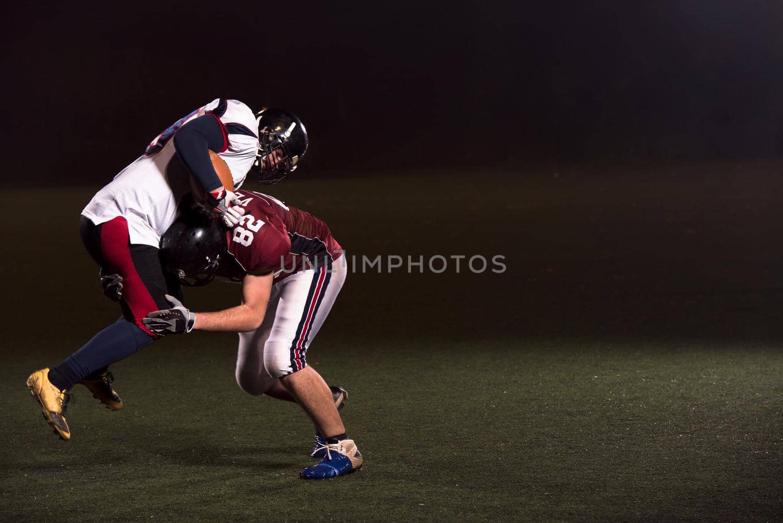 American football players in action at night game time on the field