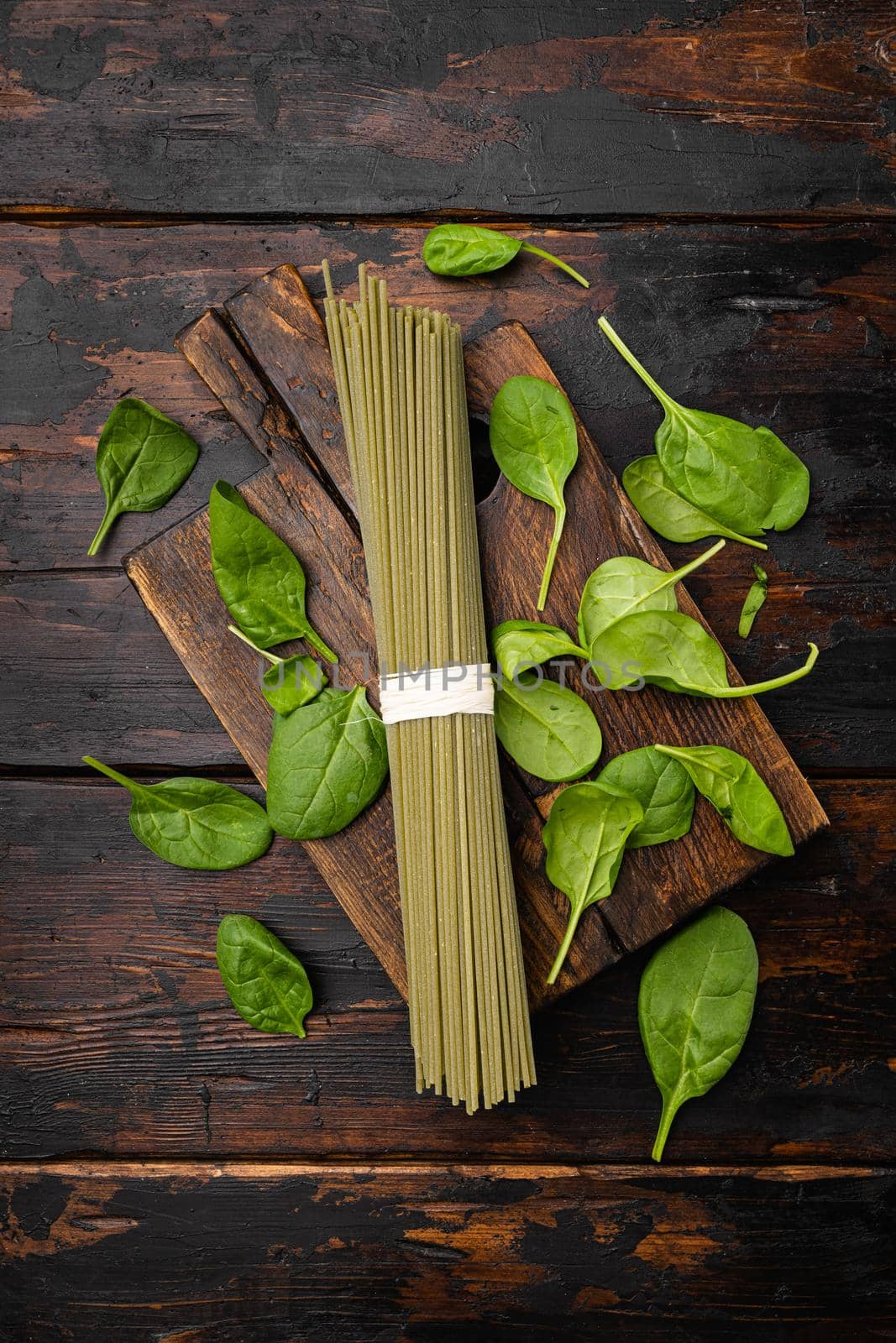 Italian uncooked green pasta spaghetti set, on old dark wooden table background, top view flat lay