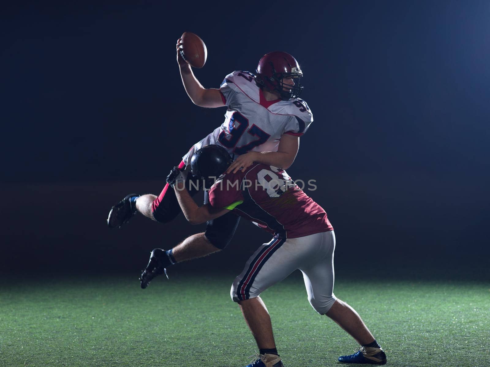 American football players in action at night game time on the field