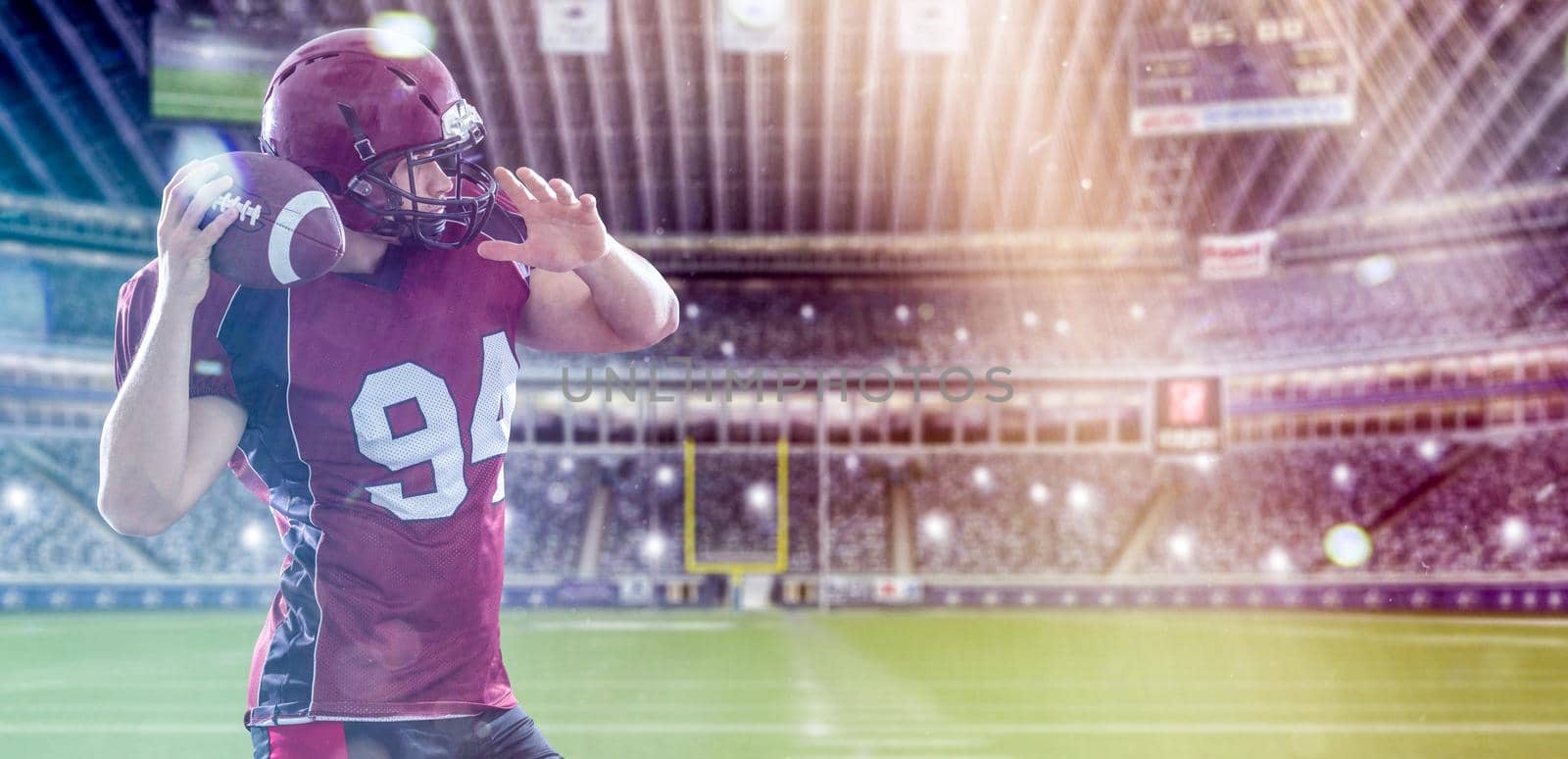 American football Player running with the ball isolated on big modern stadium field with lights and flares