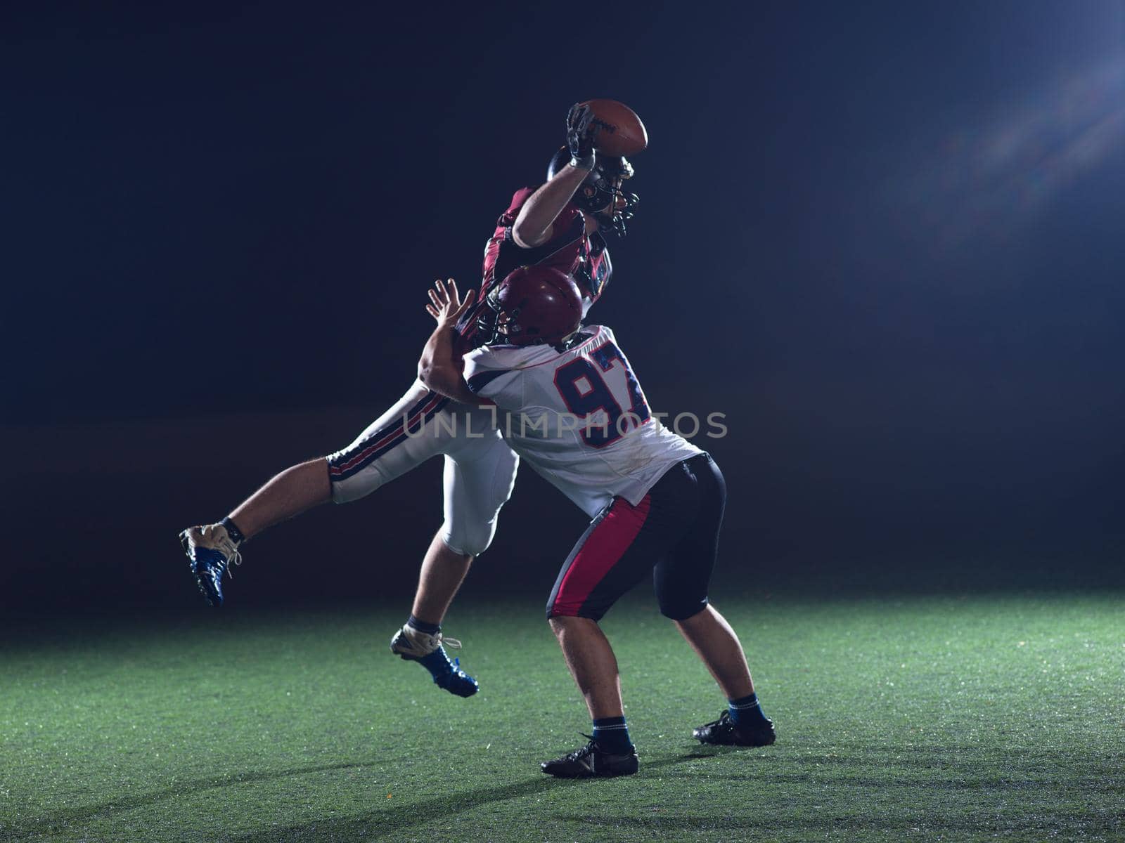 American football players in action at night game time on the field