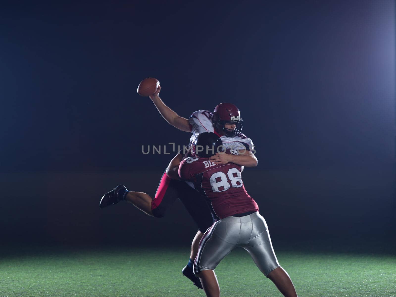 American football players in action at night game time on the field