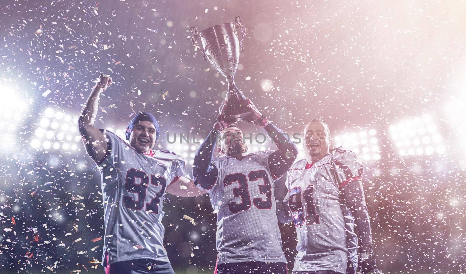american football team with trophy celebrating victory in the cup final by dotshock