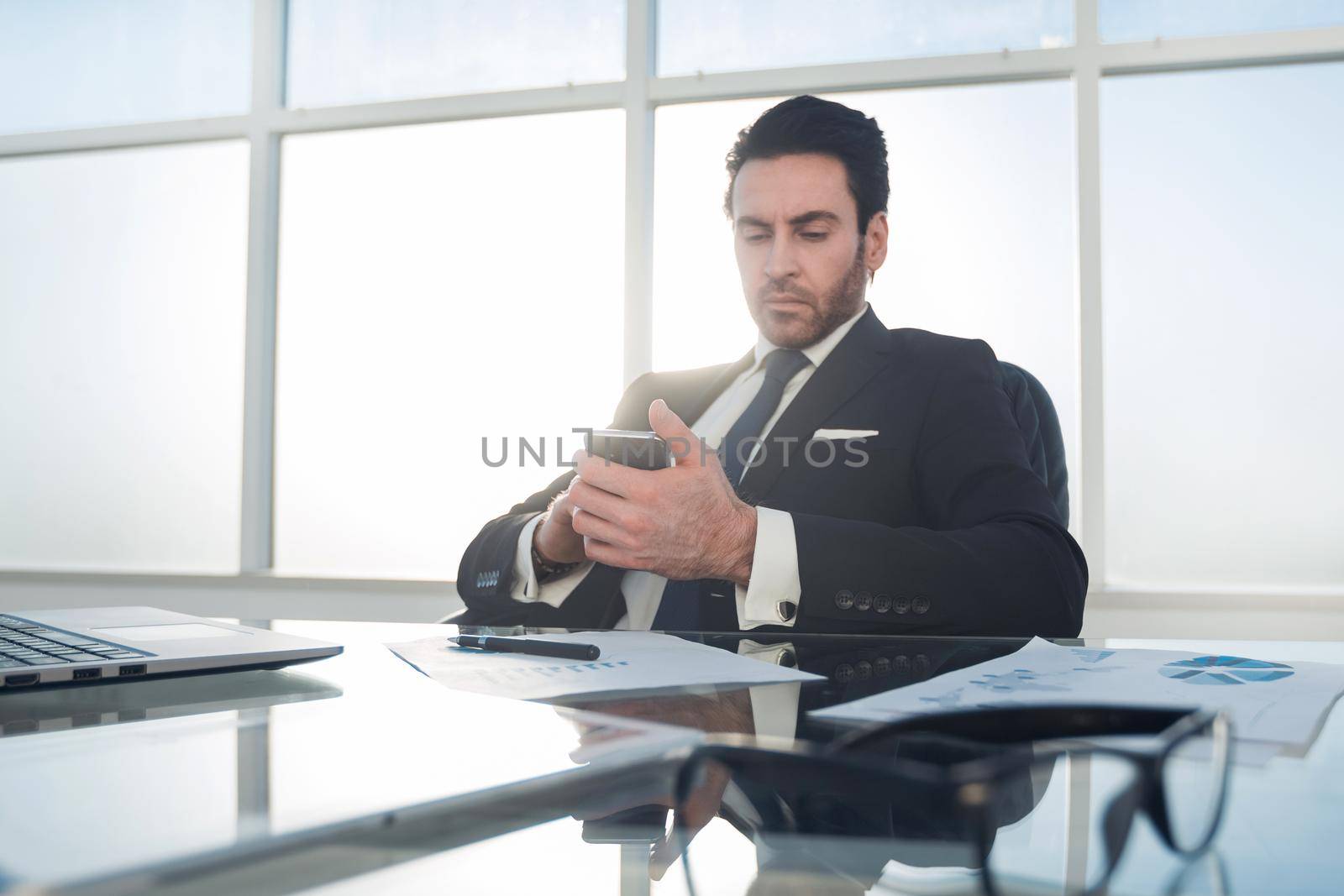 businessman using smartphone in the workplace by asdf