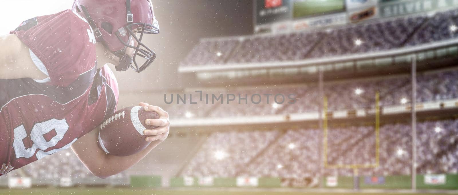 American football Player running with the ball isolated on big modern stadium field with lights and flares